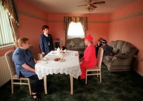 The Queen joins Mrs Susan McCarron (front left) her ten-year-old son, James and Housing Manager Liz McGinniss for tea in their home in the Castlemilk area of Glasgow in 1999. Picture: PA