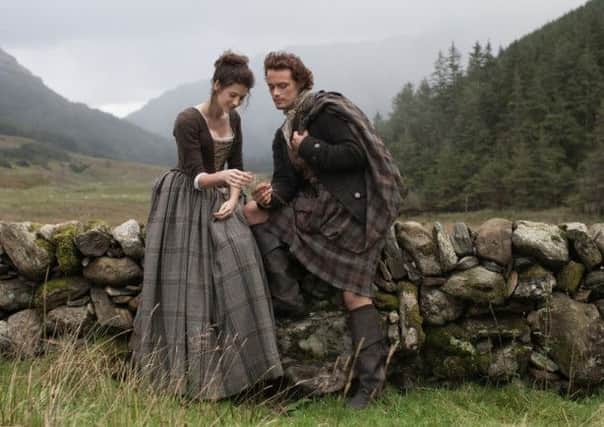 Caitriona Balfe and Sam Heughan playing Claire Randall and Jamie Fraser in Outlander.
