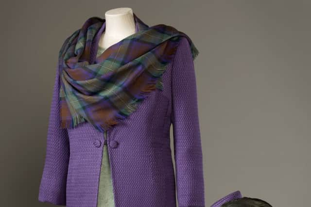 Sandra Murray, purple coat made of a silk-wool blend with a green silk-crepe and lace dress, and a shawl of purple and green Isle of Skye tartan, woven on the Island of Lewis, worn by TheÂ Queen for the official opening of the Scottish Parliament