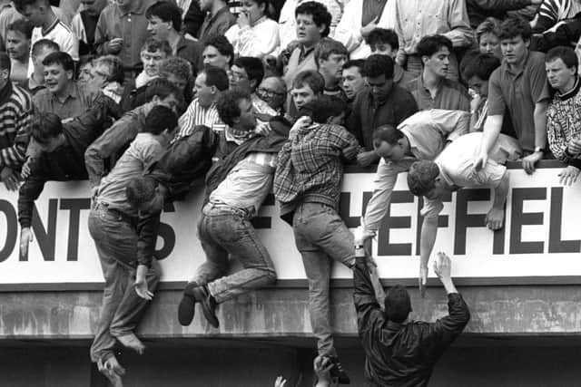 Liverpool fans climb the terraces in a desperate bid to escape severe crushing at the Leeping Lane end at Hillsborough. Picture: PA