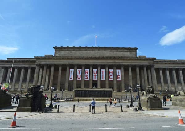 A giant banner is unveiled at St George's Hall in Liverpool after the inquest jury ruled the 96 victims  in the Hillsborough disaster had been unlawfully killed Picture: PA Wire