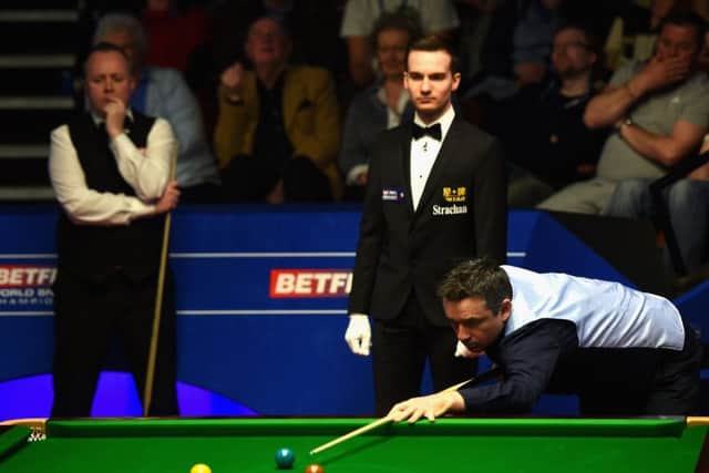 Alan McManus plays a shot as fellow Scot John Higgins watches on at the Crucible yesterday. Picture: Getty