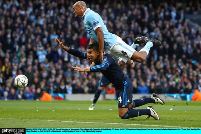 Real Madrid midfielder Casemiro succumbs to the challenge of Manchester City captain Vincent Kompany. Picture: Paul Gilham/Getty