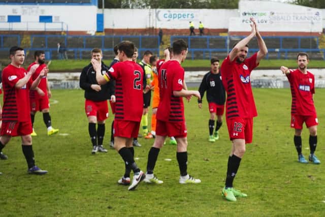Queen's Park players celebrate their win and applaud their fans
