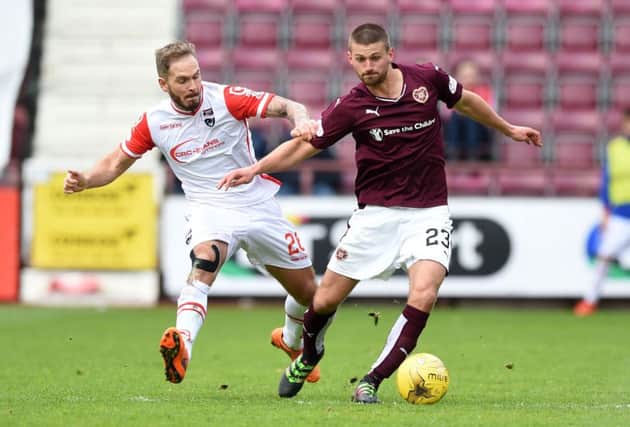 Ross Countys Martin Woods, left, and Hearts midfielder Perry Kitchen battle for possession during their 1-1 draw at Tynecastle. Picture: SNS