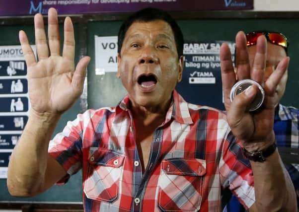 Mayor Rodrigo Duterte gestures at photographers to move back. Picture: AP
