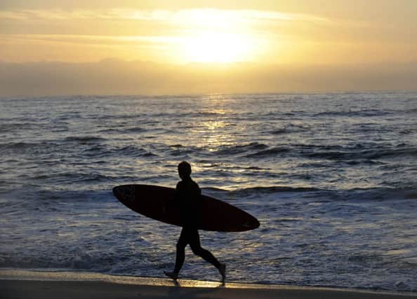 A surfer walks along the beach at Tiree. Picture: Ian Rutherford