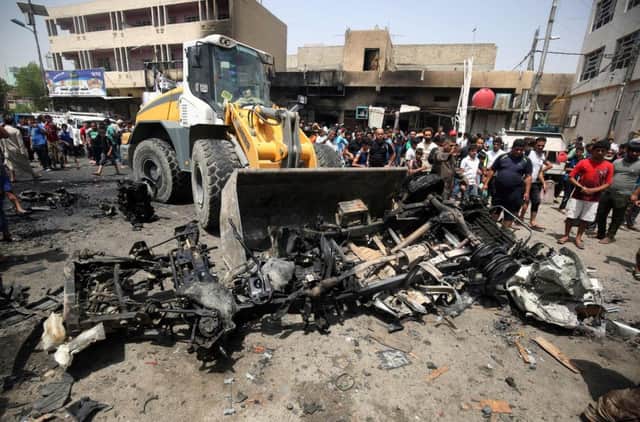 A bulldozer clears the wreckage following the vehicle bomb attack in a market area of Sadr City, Baghdad, yesterday. Picture: AFP/Getty