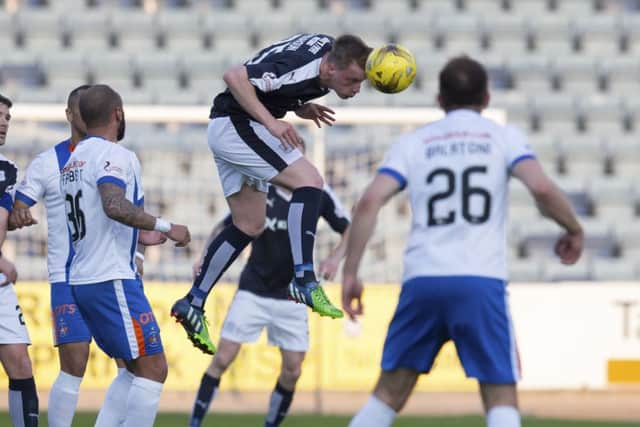 Dundees Calvin Colquhoun makes a headed clearance to thwart a Kilmarnock attack. Picture: SNS