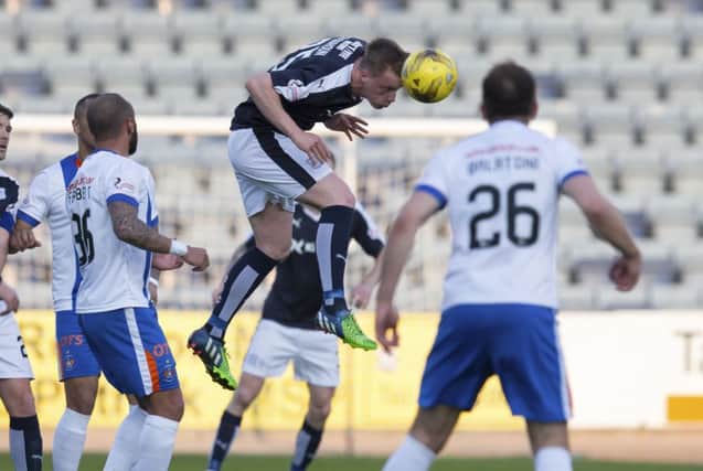 Dundees Calvin Colquhoun makes a headed clearance to thwart a Kilmarnock attack. Picture: SNS