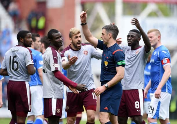 Hearts' Abiola Dauda (second from left) is shown a red card by referee Greg Aitken. Picture: PA