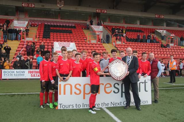 Broughton captain Fynlay Connor receives the Under-15 Shield from SSFA president Bill Barclay. Picture: Elspeth Burnside