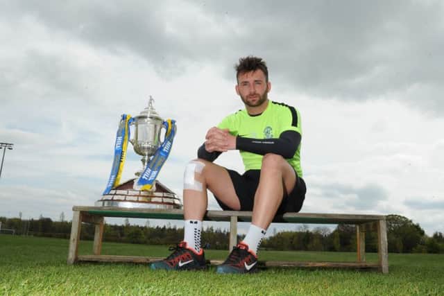 Striker James Keatings with Scottish Cup at Hibs' training base at East Mains yesterday. Picture: Eric McCowat