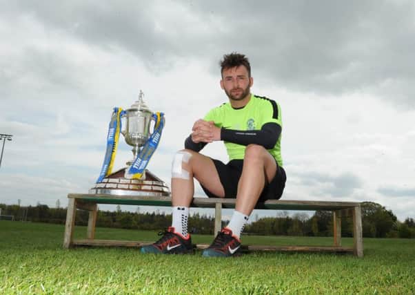 Striker James Keatings with Scottish Cup at Hibs' training base at East Mains yesterday. Picture: Eric McCowat
