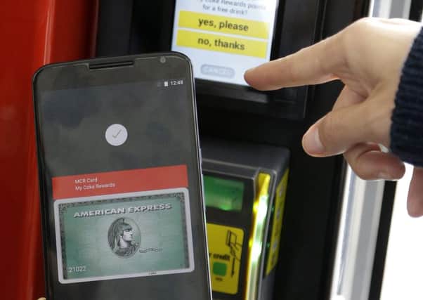 A Google employee gives a demonstration of Android Pay on a phone. Picture: AP/Jeff Chiu