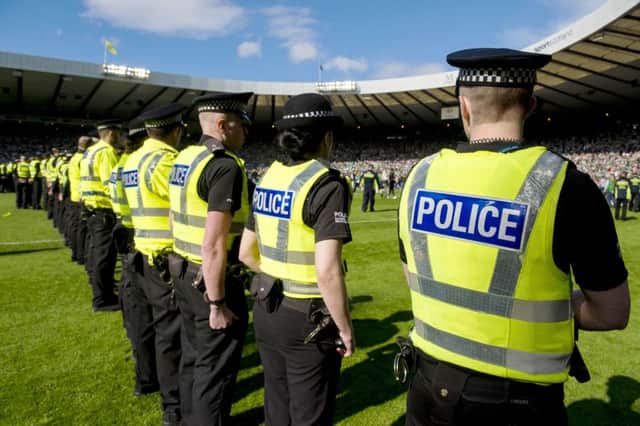 Police line up to shepherd the fans off the Hampden pitch, but should they have acted quicker to ensure that what began as a cup celebration didnt turn into something uglier? Picture: SNS