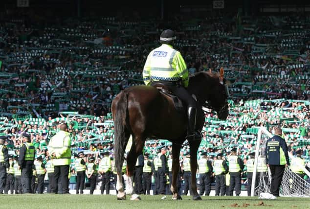 A mounted police officer looks on as Hibs fans celebrate the Scottish Cup final win over Rangers. Picture: Ian MacNicol/Getty