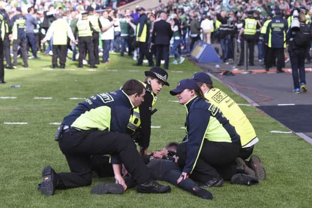 Police and stewards restrain a fan following the match. Picture: SNS Group