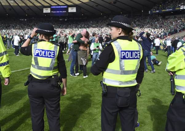 Police line up on the pitch at full-time after a pitch invasion