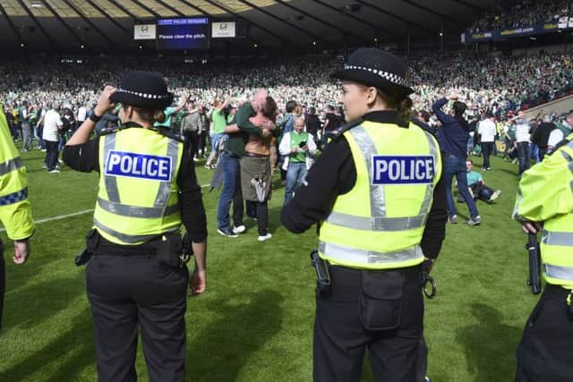 Police line up on the pitch at full-time after a pitch invasion