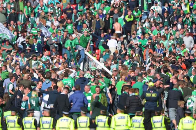 Police officers set up a cordon as Hibs supporters run on to the Hampden pitch to celebrate. Picture: SNS