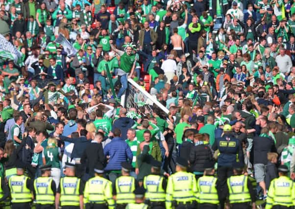 Police officers set up a cordon as Hibs supporters run on to the Hampden pitch to celebrate. Picture: SNS