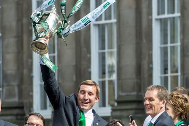 Hibernian manager Alan Stubbs holds aloft the William Hill Scottish Cup as his squad embark on their victory parade through Edinburgh. Picture: SNS