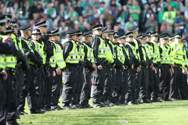 Police form a cordon as Hibs fans invade the pitch at the final whistle after winning the Scottish Cup final. Picture: Getty