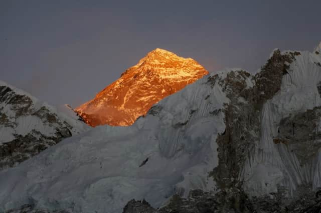 Mount Everest glows gold in the suns light as three die on its slopes at the end of the climbing season. Picture: AP