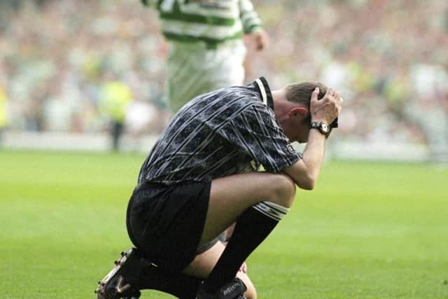 Hugh Dallas attempts crouches on the pitch dazed after being struck by a coin. Picture: SNS Group