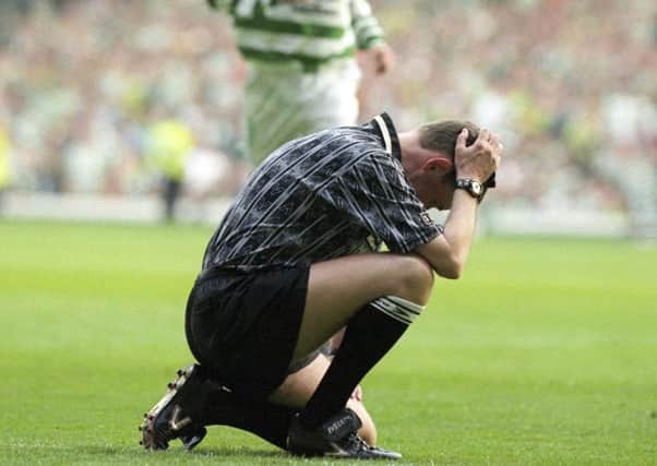 Hugh Dallas attempts crouches on the pitch dazed after being struck by a coin. Picture: SNS Group