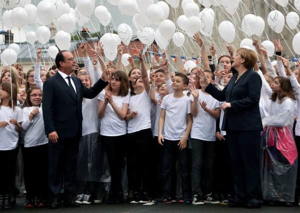Francois Hollande, left, and Angela Merkel attend a balloon drop to mark the centenary of the Battle of Verdun. Picture: AP