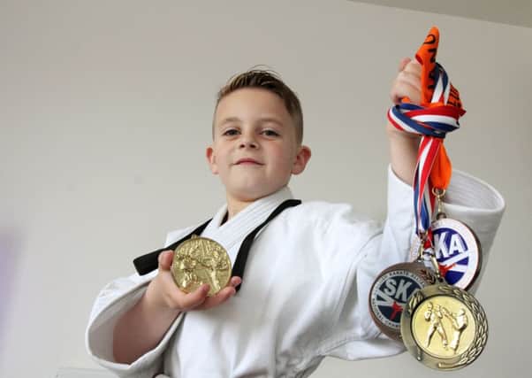 Harrison Loftus with the medals he has won since he started going to classes to strengthen his legs. Picture: John Jeffay