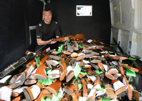 Assistant Chief Constable Mark Williams shows some of the 2,301 weapons which have been surrendered. Picture: SWNS