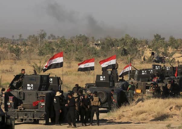 Smoke billows on the horizon as Iraqi military forces prepare for an offensive into Fallujah to retake the city. Picture: AP