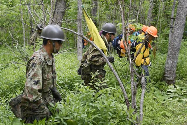 Members of the Ground Self-Defense Force conduct a search operation for Yamato Tanooka. Picture: Daisuke Suzuki/Kyodo News via AP