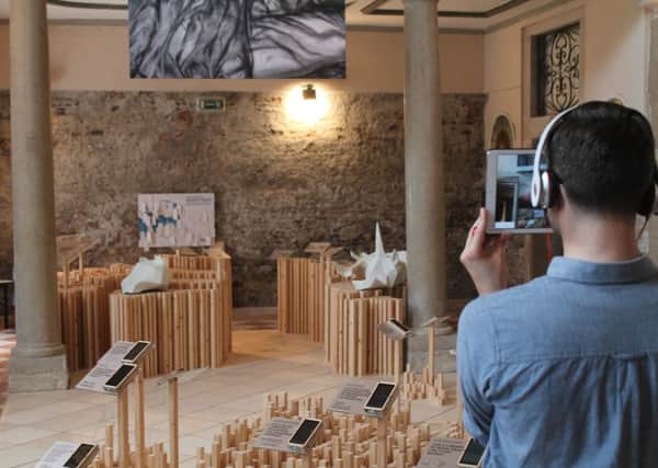A visitor to the Scotland exhibit in Venice uses the augmented reality technology
