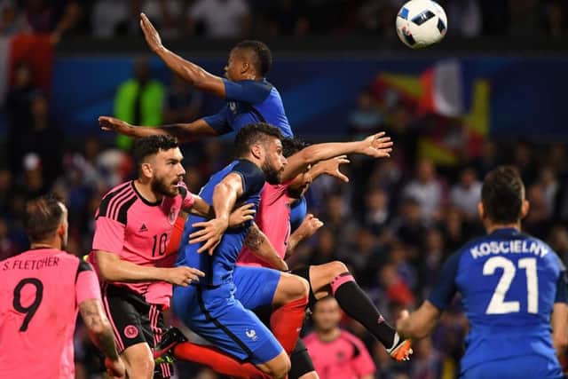 France's Olivier Giroud and Patrice Evra challenge for the ball which fell to Laurent Koscielny, right, who headed home the third goal. Franck Fife/AFP/Getty Images