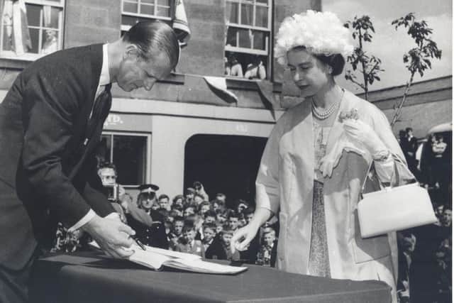 The Queen and the Duke of Edinburgh sign the visitors book while in Dalkeith. Photo courtesy Midlothian Council Local Studies.