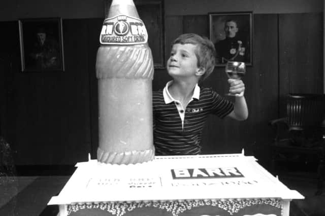 Graham Barr raises a glass beside a cake to celebrate the 150th anniversary of the Irn-Bru company in Glasgow in August 1980.