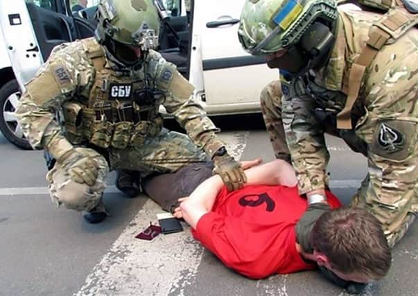 Security officers detaining an unidentified French national at the border with Poland. Picture: AFP/Getty Images