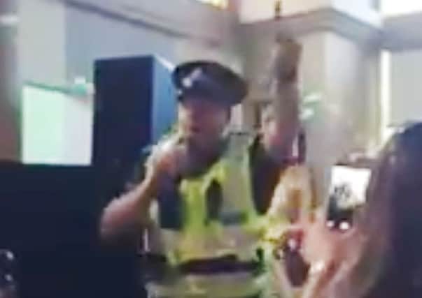 Sergeant Jon Harris singing Gloria Gaynor's I Will Survive while in full uniform to cheers from drinkers at Glasgow's Waterloo Bar. Picture: PA