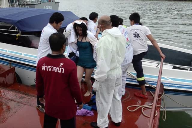 Passengers are helped ashore after being rescued following the crash between two speedboats. Picture: AP