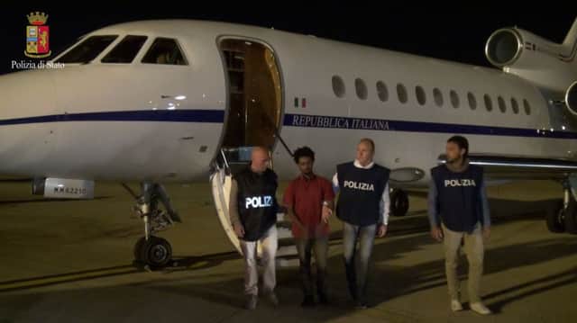Flanked by police officers, Mered Medhanie arrives in Italy. Picture: Getty
