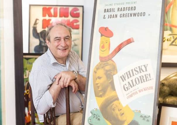 Iain Maclean, producer of the forthcoming re-make of Whisky Galore, with a poster released for the original movie. It is part of an exhibition at Compass Gallery in Glasgow displaying rare film posters. Picture: Stuart Wallace