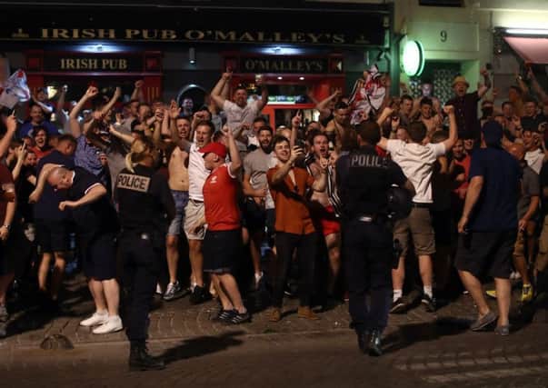 Police officers look on as England fans shout and chant outside a bar. Picture: Getty