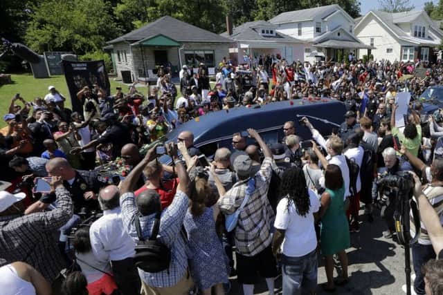 The flower-strewn hearse is surrounded by fans as it passes the boxers childhood home. Picture: AP