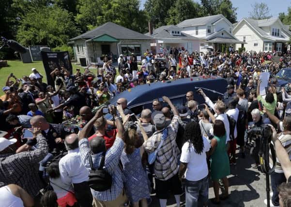 The flower-strewn hearse is surrounded by fans as it passes the boxers childhood home. Picture: AP