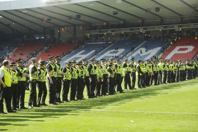 Police line the pitch following the violence after the Scottish Cup Final between Hibs and Rangers. Picture: TSPL