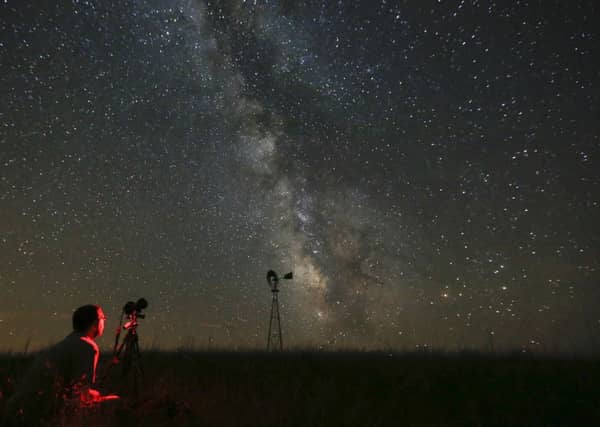 Lane Hickenbottom photographs the night sky near Callaway, Nebraska. Picture: Travis Heying/The Wichita Eagle via AP